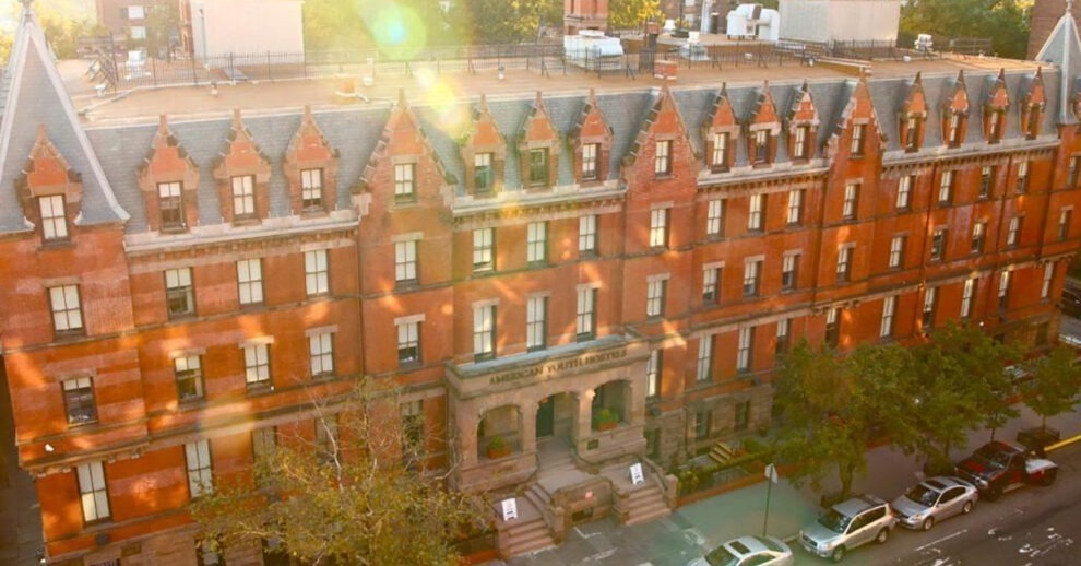 Hostel em Nova York: Um hostel de tijolos vermelhos com vários andares visto do alto durante o pôr do sol