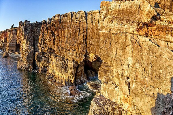 Foto da formação rochosa conhecida como "Boca do Inferno", rodeada pelo mar.