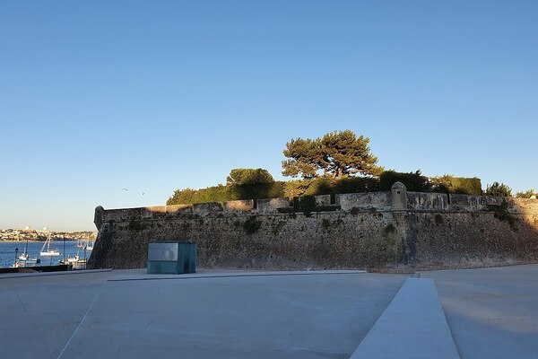 Foto da fortaleza conhecida como Cidadela de Cascais. Além da fortificação de pedra, na parte de cima há árvores.