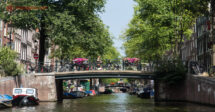 O que fazer em Jordaan, Amsterdam: Uma ponte vista da água no bairro de Jordaan, com uma mulher andando de bicicleta por ela