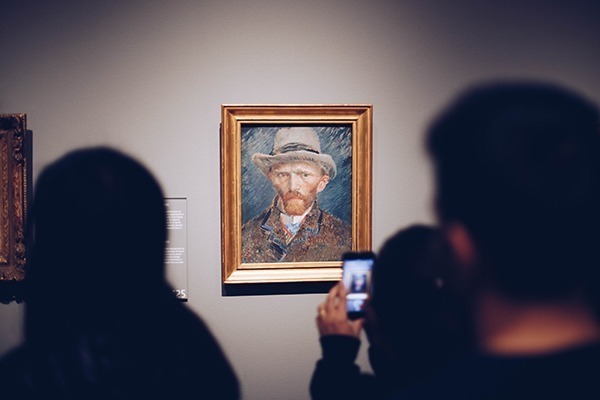 Um quadro do Van Gogh dentro do museu Van Gogh com várias pessoas tirando foto dele