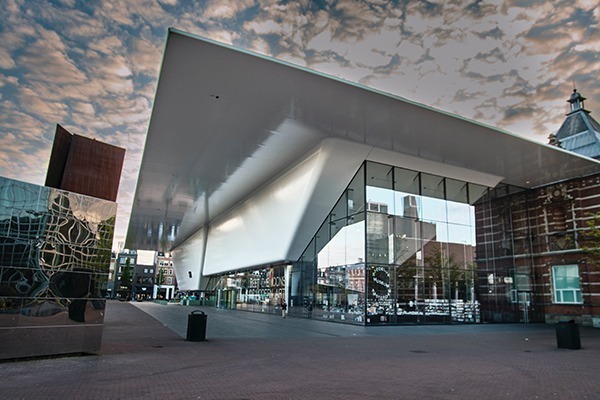 O exterior d Stedelijk Museum, com suas paredes de vidro e teto inclinado branco