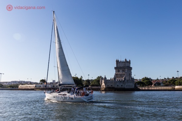 O que fazer em Belém: um veleiro passando na frente à Torre de Belém num lindo dia ensolarado