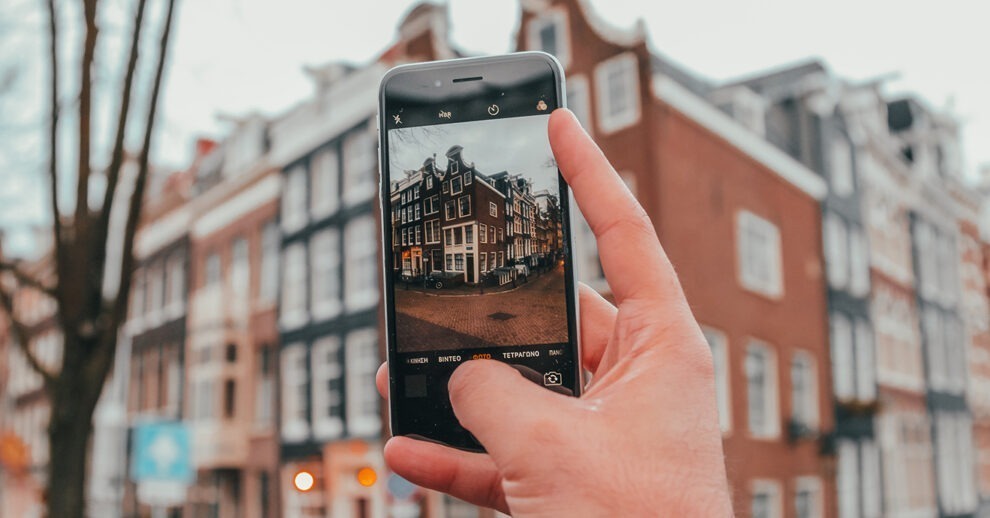 O que fazer em De Pijp Amsterdam: Um homem tirando uma foto de celular de um típico prédio holandês