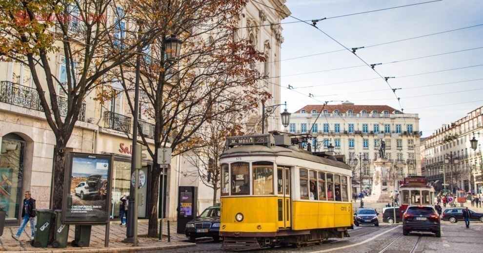 O que fazer no Chiado: Um bonde amarelo passa em frente a vários prédios antigos no bairro do Chiado, em Lisboa