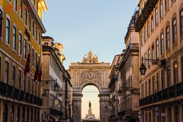 Arco da Rua Augusta ao fundo de uma rua em Lisboa