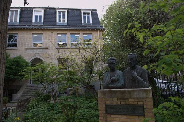 Foto do busto de Marie Curie e seu marido na frente do museu em legado da cientista polonesa