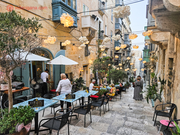 Uma escadaria em Malta cheia de mesas de restaurantes onde as pessoas podem se sentar para comer