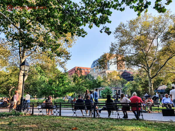 Pessoas sentadas em um banco em Greenwich Village Park