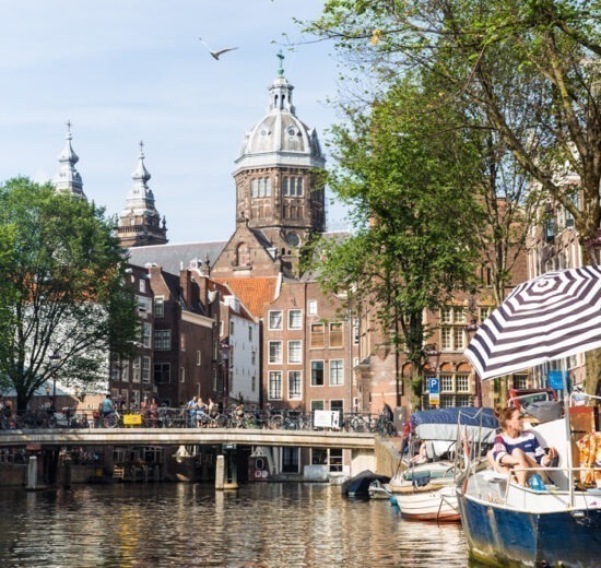 Clima em Amsterdam: paisagem típica da capital holandesa - barcos e casas coloridas, além dos canais.