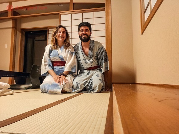 O que fazer em Takayama: eu e Carlos vestidos de kimonos, sentados no chão de um ryokan, olhando pra câmera