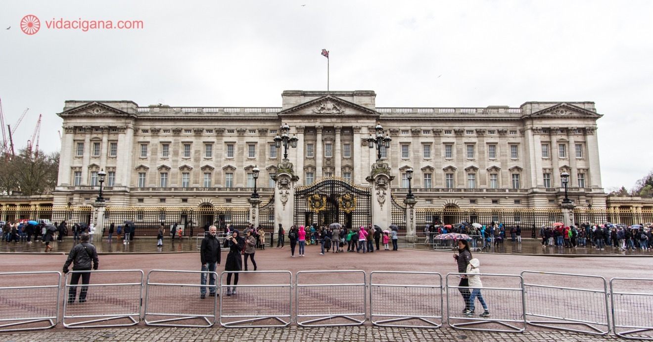 Foto do Palácio de Buckinham. A imagem mostra a fachada do edifício, que é morada oficial da família Real Britânica. 