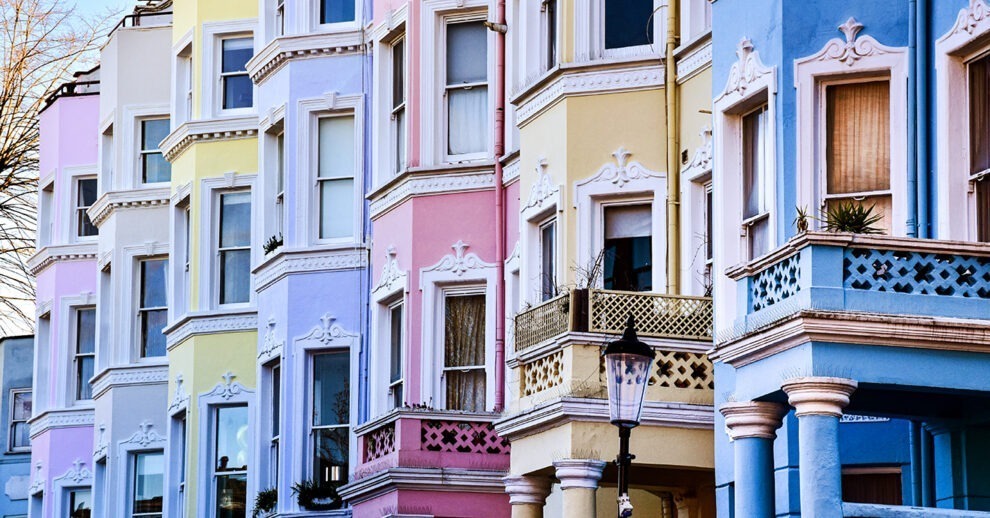 Descubra o que fazer em Notting Hill, o bairro mais colorido de Londres, no Reino Unido. A foto mostra uma fileira de casas geminadas, de diferentes cores.