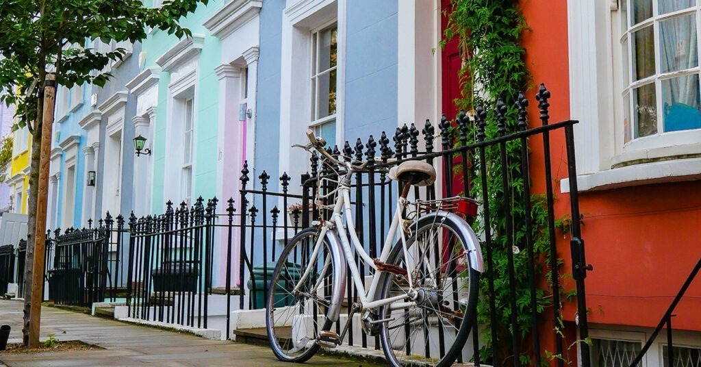 Foto de casas geminadas coloridas com uma bicicleta apoiada em uma grade