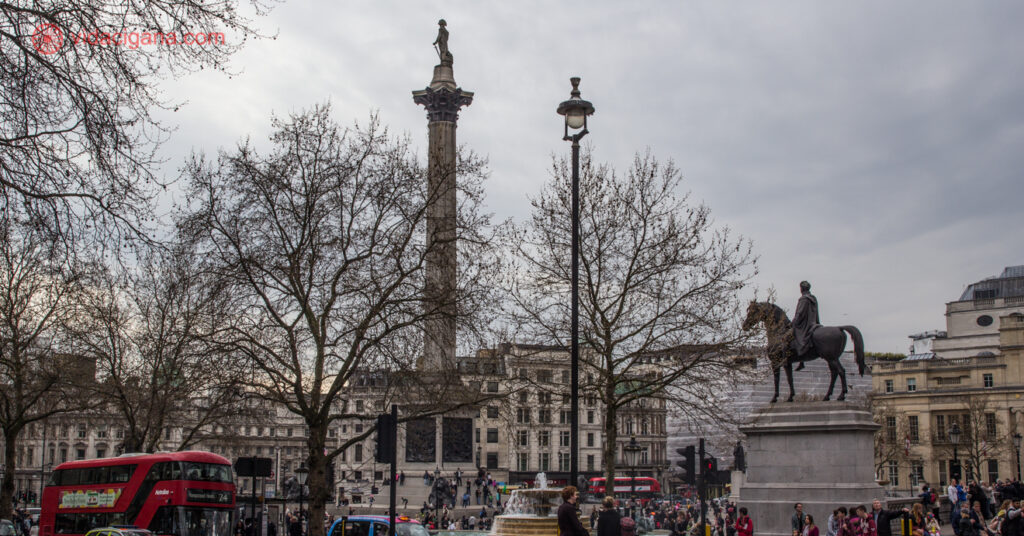 A Trafalgar Square num dia nublado, com a Coluna de Nelson no centro e uma estátua equestre à direita
