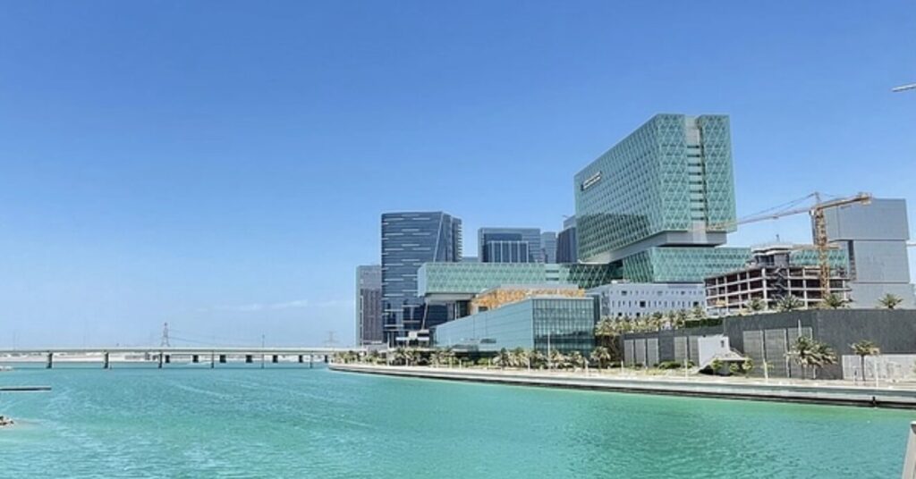 Vista dos prédios modernos de Al Maryah Island na beira do Golfo Pérsico com águas bem claras