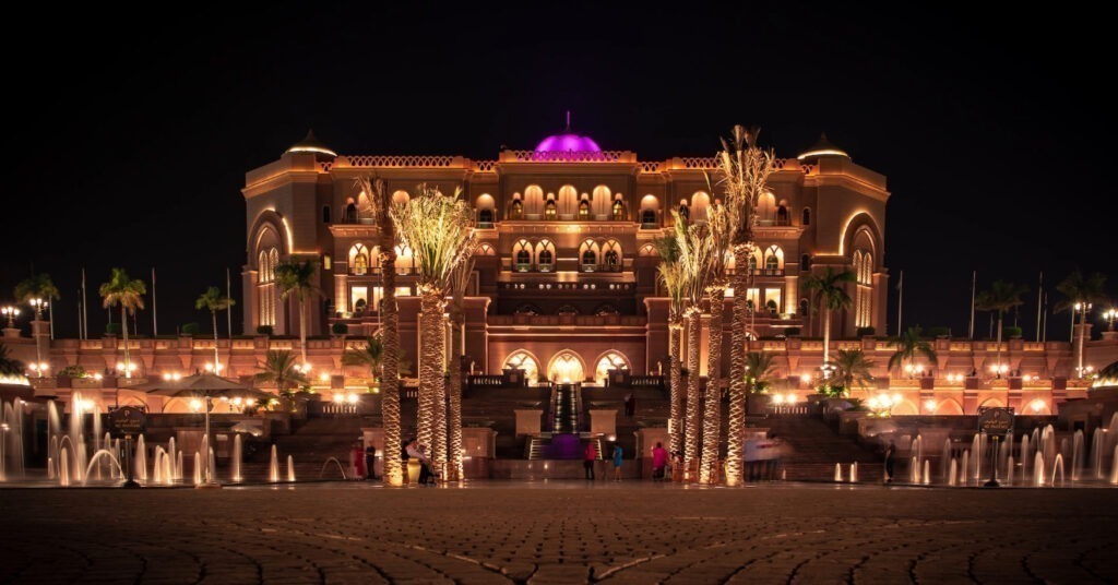 Foto da fachada luminada do Emirates Palace Hotel em Abu Dhabi.