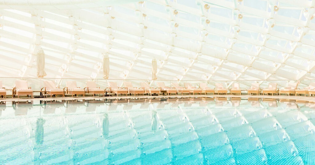 Foto do interior de um hotel na região de Yas Island, com uma piscina refletindo o teto inusitado