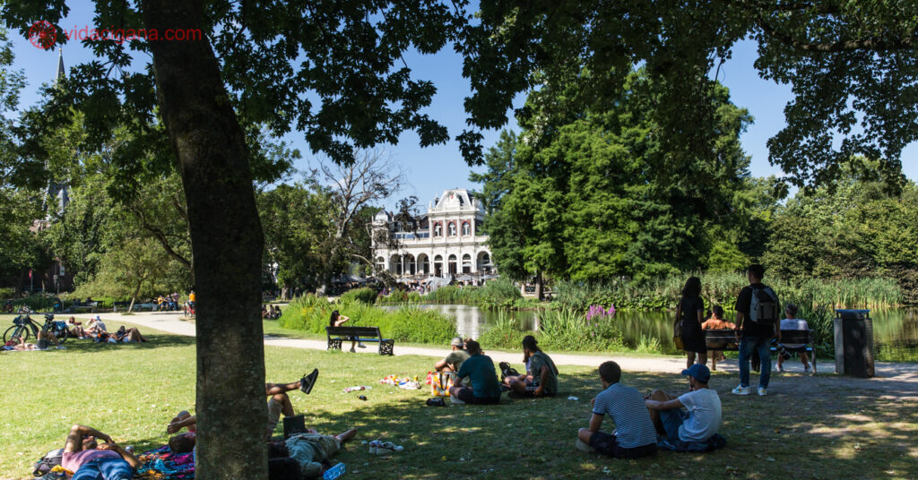 É muito comum encontrar cenas como as da imagem na Holanda. Turistas e moradores locais sentados nas sombras das árvores enquanto descansam em parques de Amsterdam. 