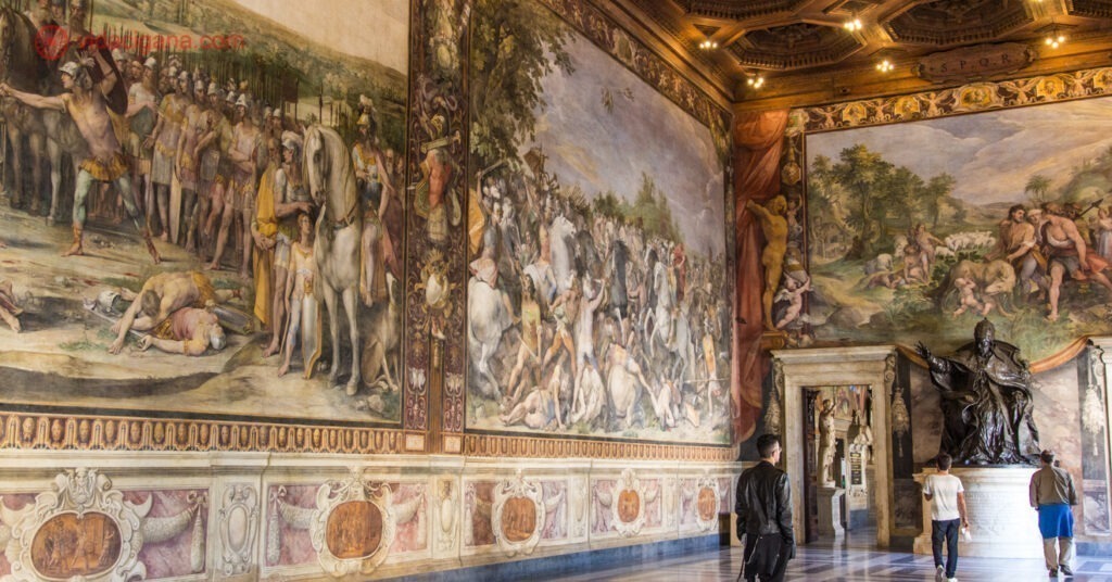 Interior de uma das salas dos Museus Capitolinos. Nas paredes, pinturas gigantes estão expostas. 