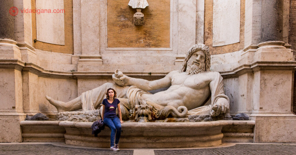 Larissa posa em frente a uma grande escultura dos Museus Capitolinos. 