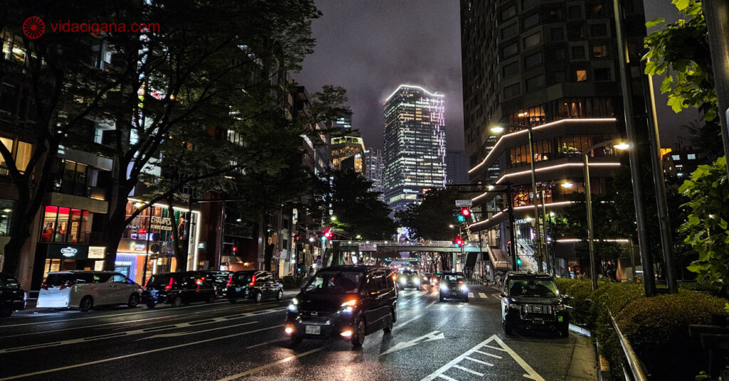 Uma rua em Harajuku cheia de prédios modernos durante a noite