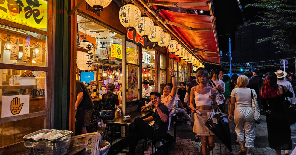 O que fazer em Shinjuku: um restaurante cheio de lanternas orientais acesas e pessoas sentadas comendo ou passando pela calçada.