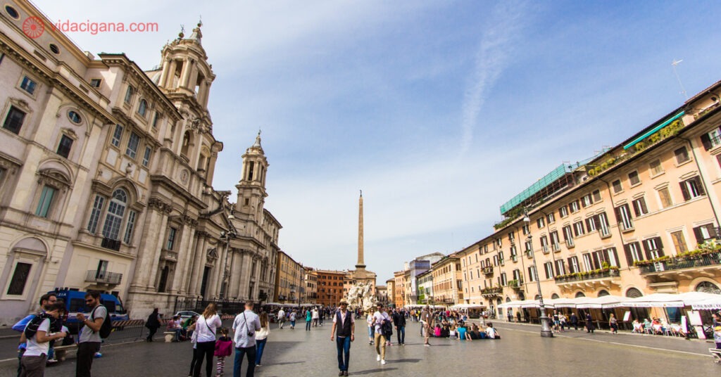 A imagem mostra a Piazza Navona, com o obelisco ao centro e prédios ao seu redor. 
