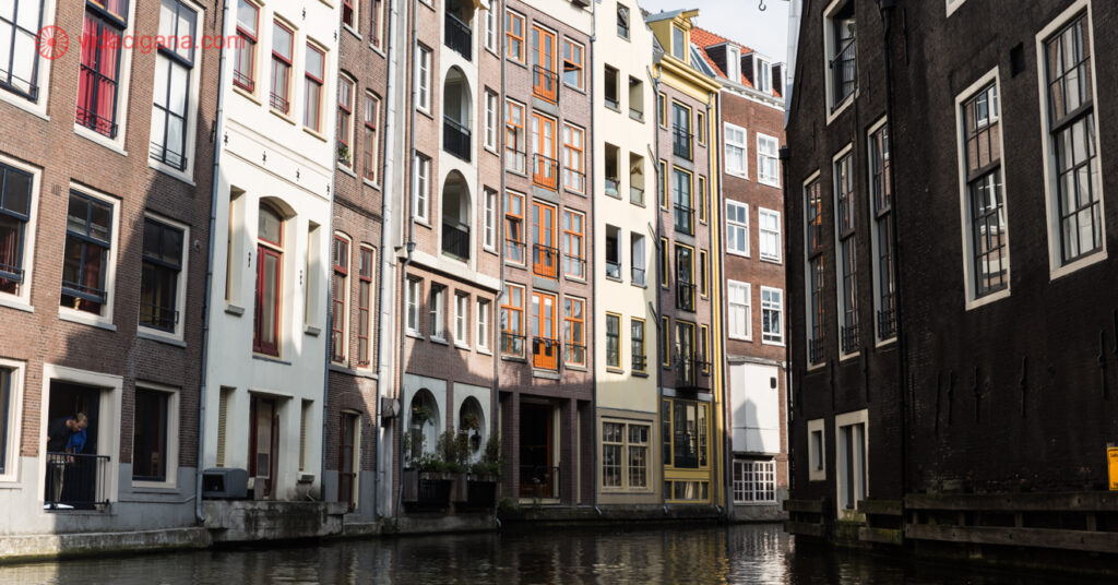 A imagem mostra edifícios do centro de Amsterdam, construídos em meio aos canais da cidade. 
