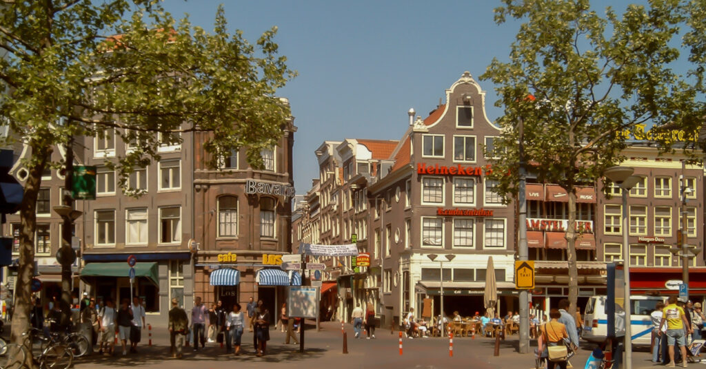 A imagem mostra os prédios e estabelecimentos ao redor da movimentada Rembrandtplein.