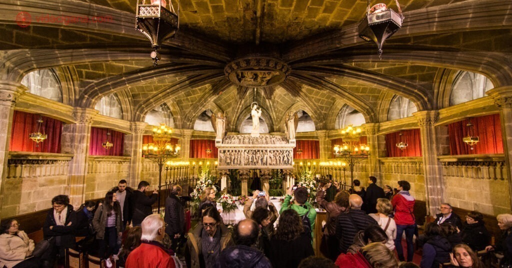 Interior da Catedral de Barcelona. Na foto, muitos visitantes apreciam seus detalhes ornamentais. 