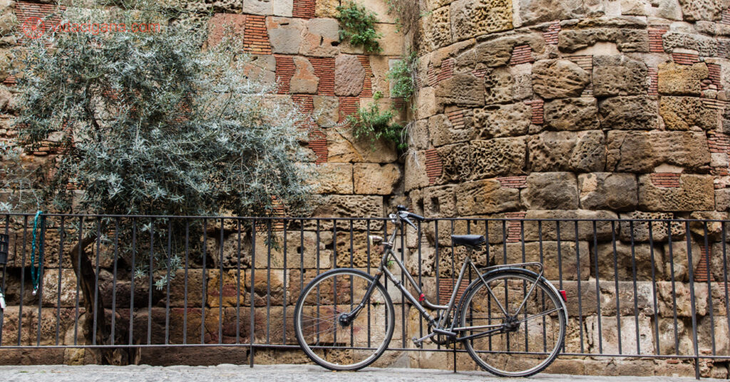 Uma bicicleta em frente a muralha romana em Barcelona