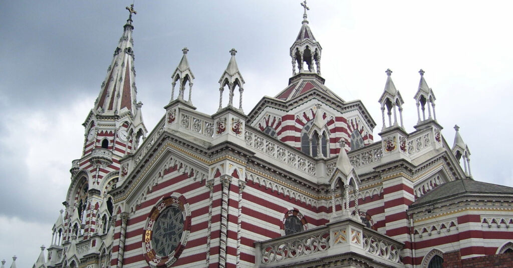 Torres da fachada Santuario Nuestra Señora del Carmen, que é listrada de vermelho e branco, com tijolos à vista e vitrais. 