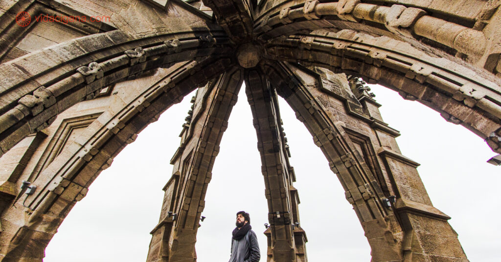 Um homem olhando pra uma cúpula vazada no Monumento a William Wallace