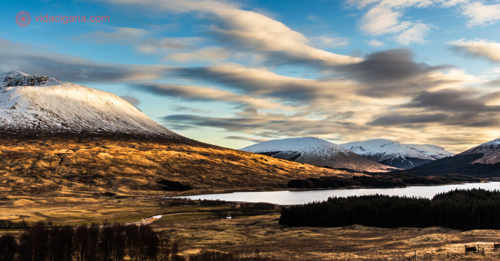 Montanhas nevadas na beira de um lago nas Highlands escocesas
