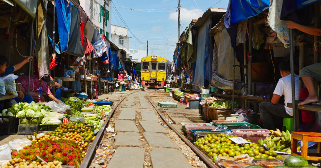 Barracas de frutas e legumes ao redor do trilho do trem em Meaklong, próximo a Bangkok. 