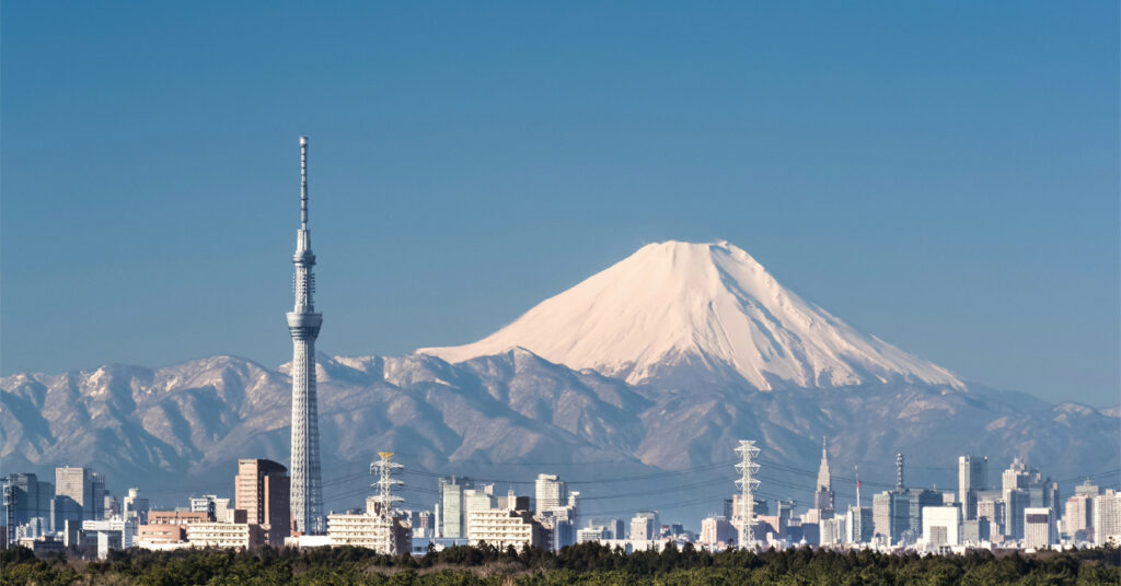 A torre de transmissão Tóquio Skytree, um dos mirantes mais procurados da cidade. Ao fundo, vemos silhuetas dos prédios e o Monte Fuiji. 