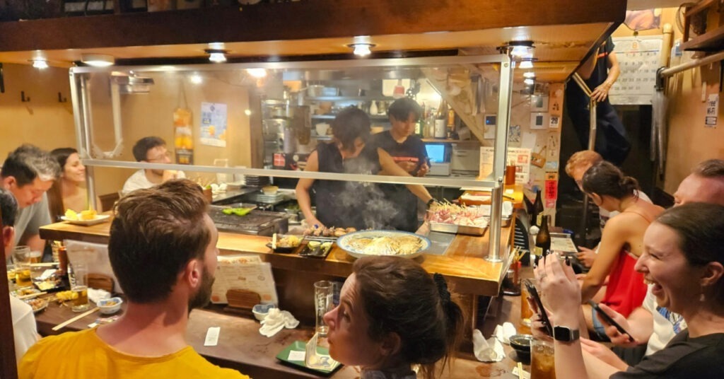 Pessoas se divertem em restaurante típico no Japão. Confira dicas do que fazer em Tóquio! 