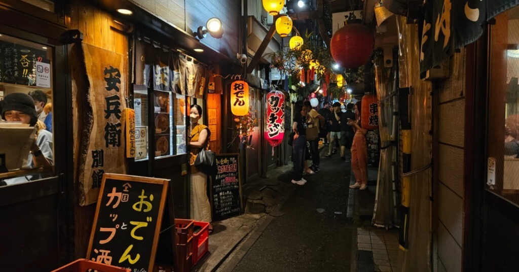 Pessoas nos pequenos restaurantes da calçada em Omoide Yokocho, uma boa região para encontrar o que fazer em Tóquio. 